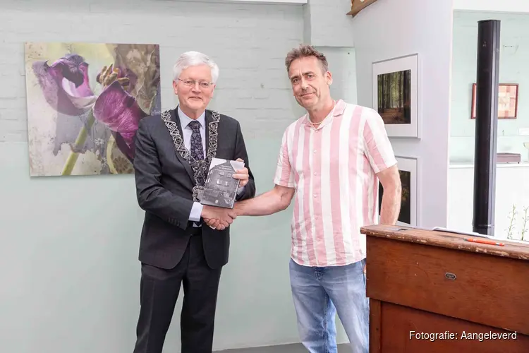 Burgemeester eert Tilburgse textiel recycling pionier H.J. Clijsen met in ontvangst name boek